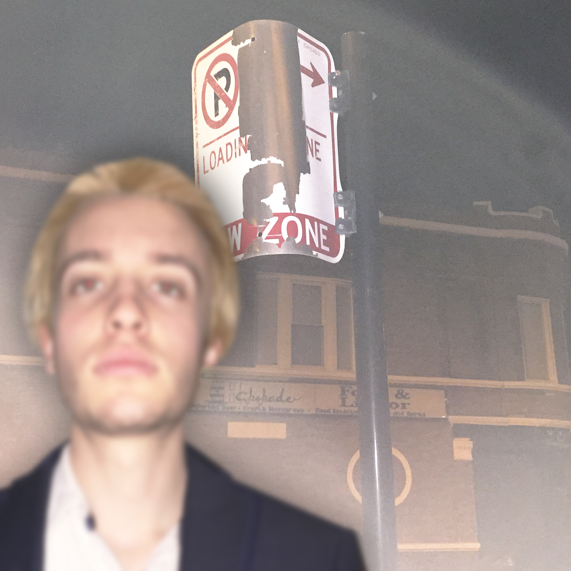 Butler out of focus in front of a broken parking sign outside at night